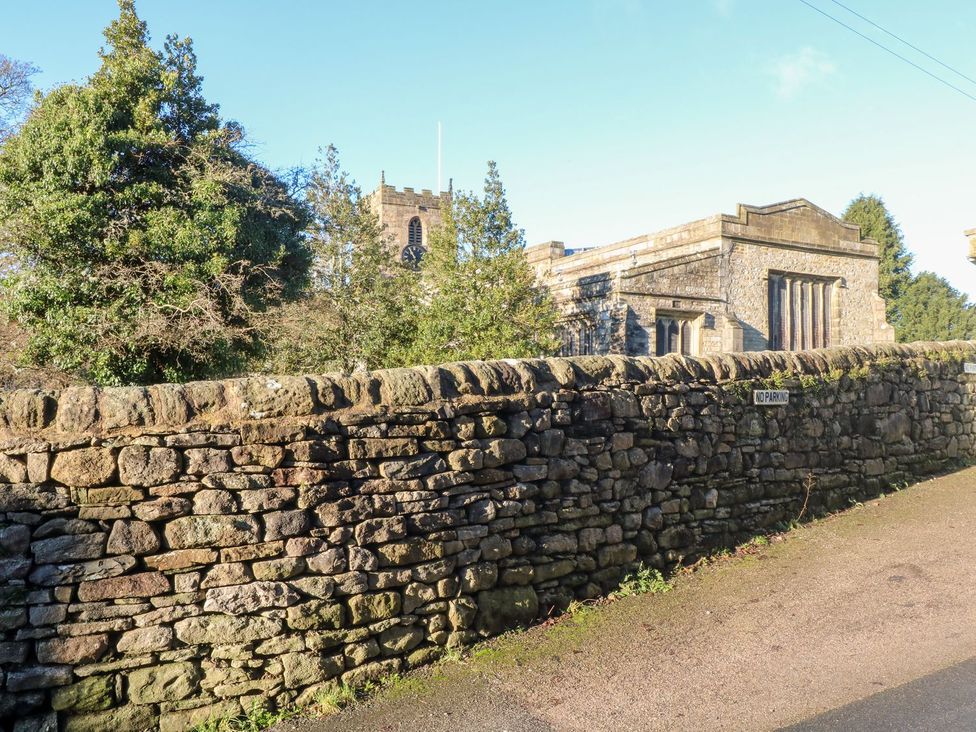 A church with a clock tower behind a stone wall at TOB Grave Prospect