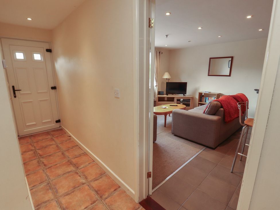 A hallway leading to a living room with a sofa and television at Valley View in Cleator Moor