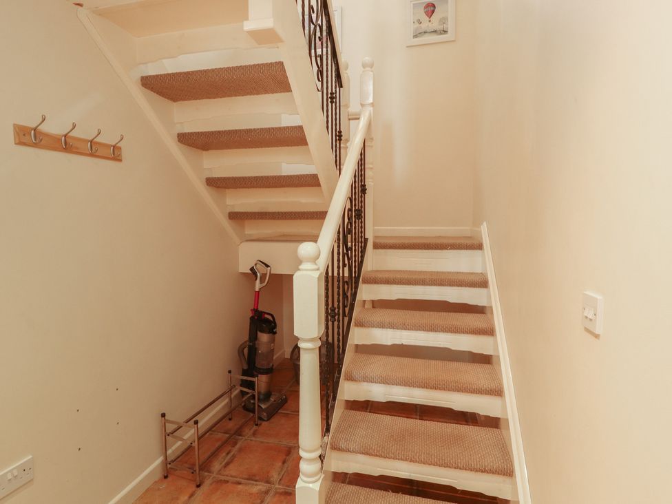 A staircase with a vacuum cleaner and coat hooks at Valley View in Cleator Moor