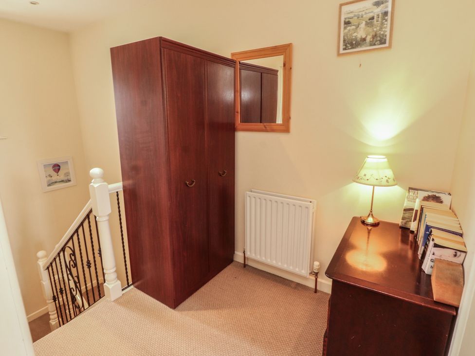 A landing with a wardrobe, lamp, and bookshelf at Valley View in Cleator Moor