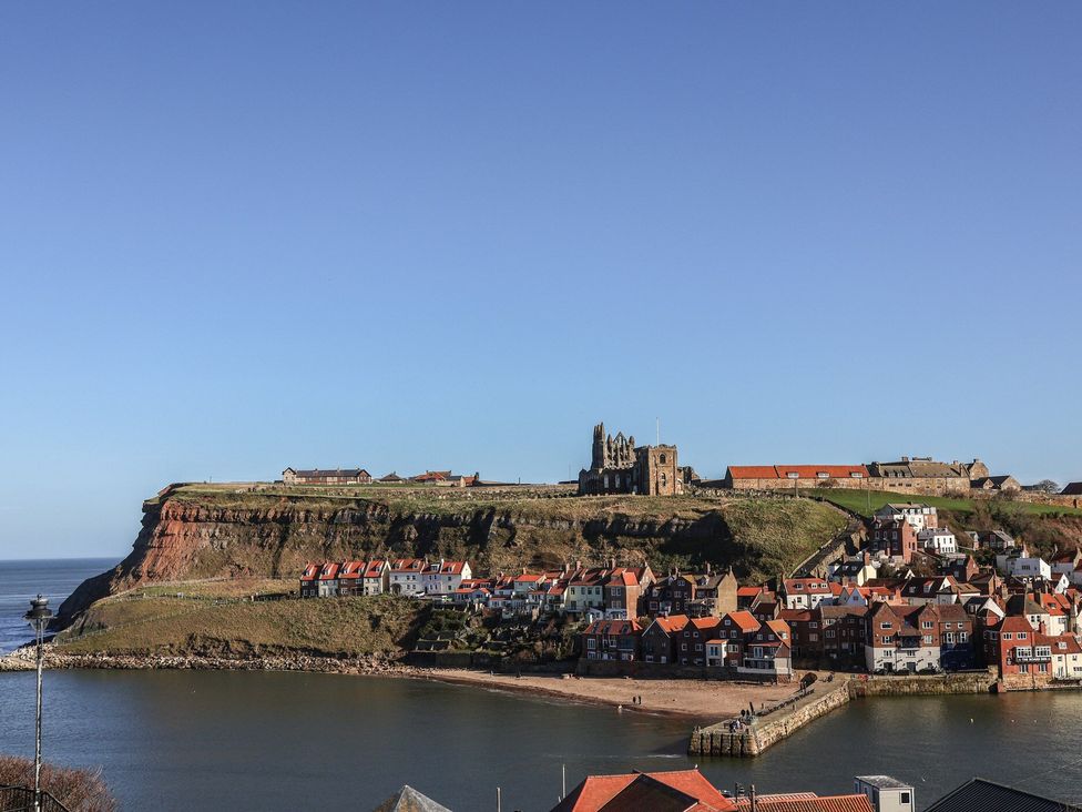 A coastal view with buildings and a cliff at Juniper Lodge in Whitby