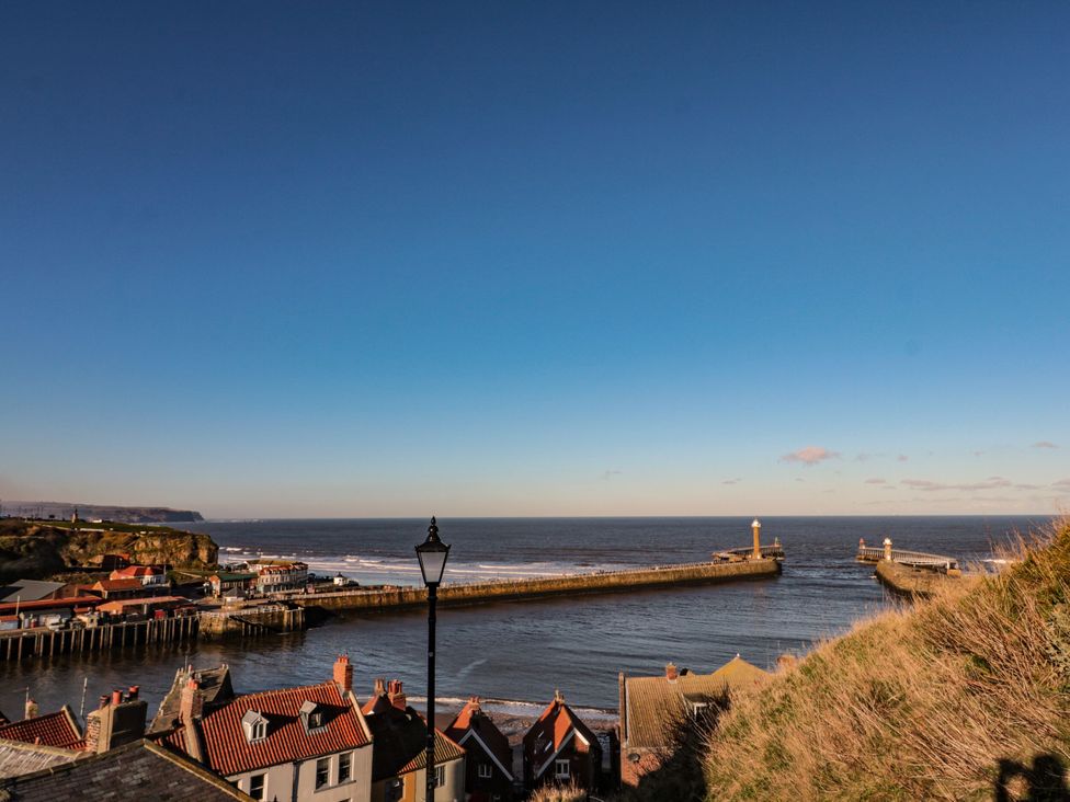 A view of the sea and pier with houses at Juniper Lodge in Whitby