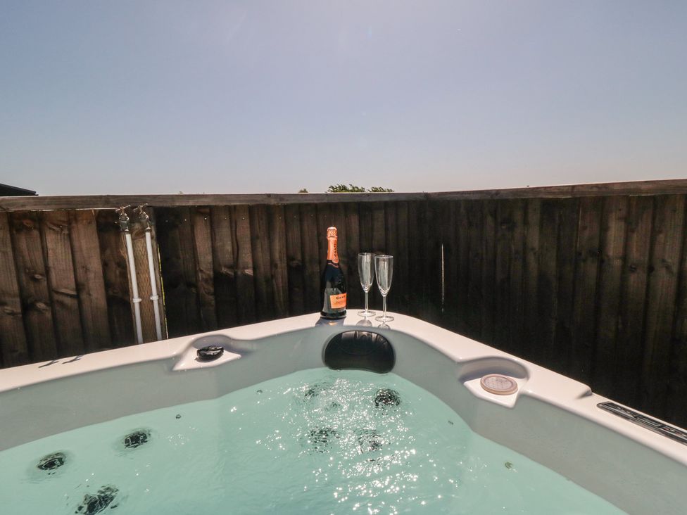 A hot tub with champagne and glasses at Willow Lodge in Whitby