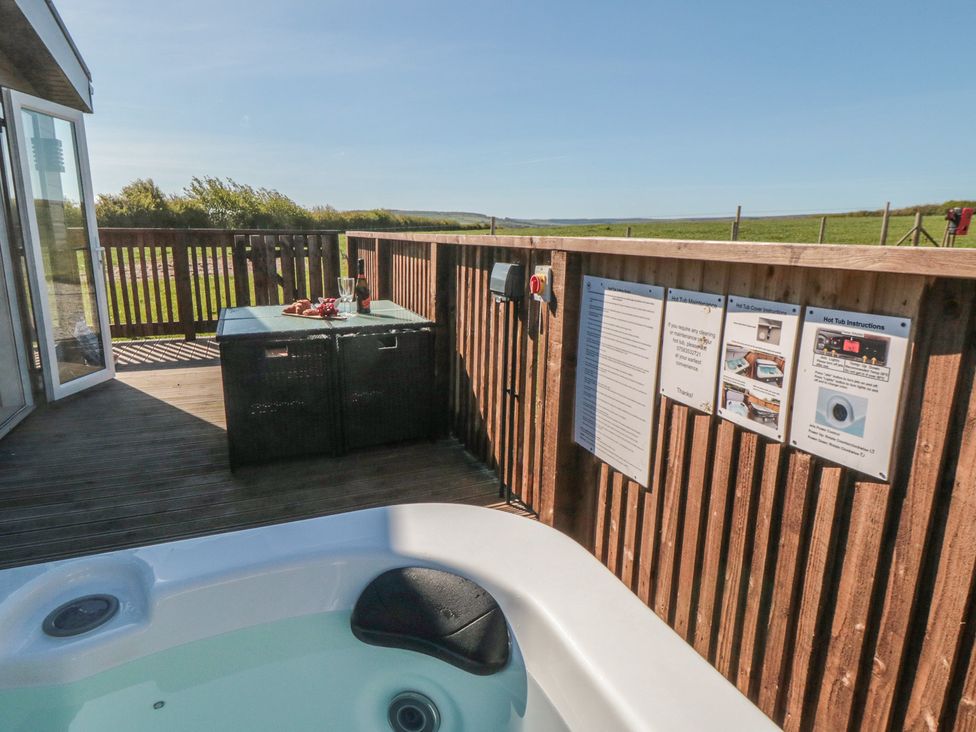 An outdoor area with a hot tub and seating at Magnolia Lodge in Whitby