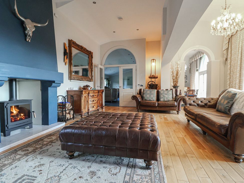 A living room with a fireplace and sofas at The Colonnade in Trefnant