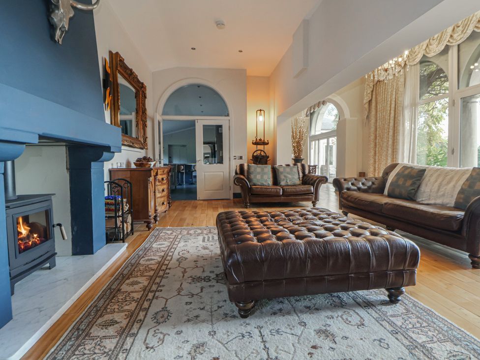 A living room with a fireplace and seating area at The Colonnade in Trefnant