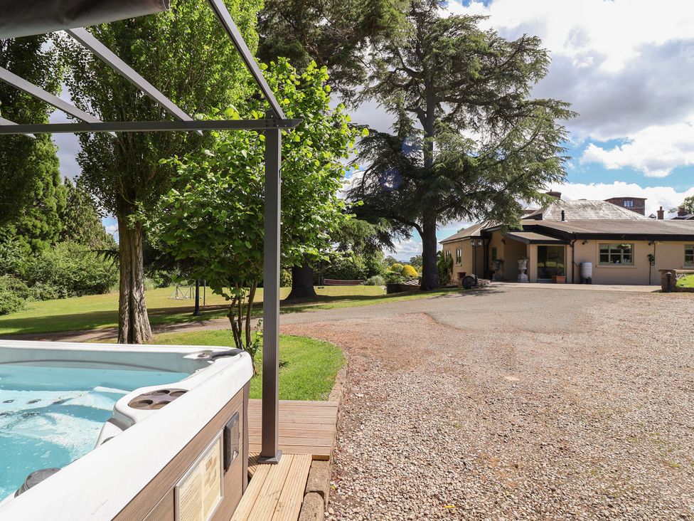 A garden with a hot tub and trees at The Colonnade in Trefnant