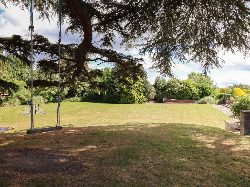 A garden with swings and trees at The Colonnade in Trefnant