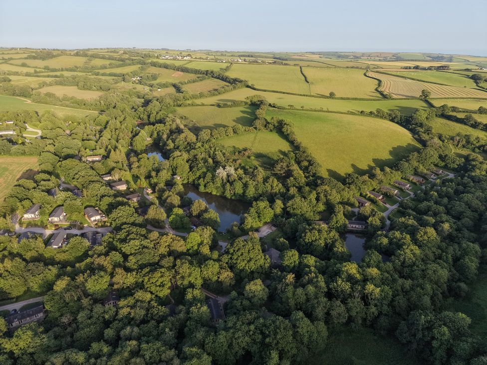 Aerial view of houses near water and fields at 1 Hedgerows in Lanreath