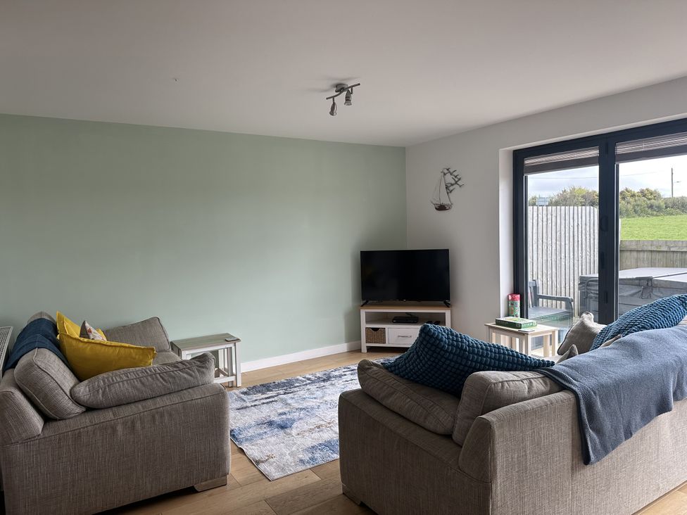 A living room with sofas and a television at 9 Coastguard Cottages Woolacombe