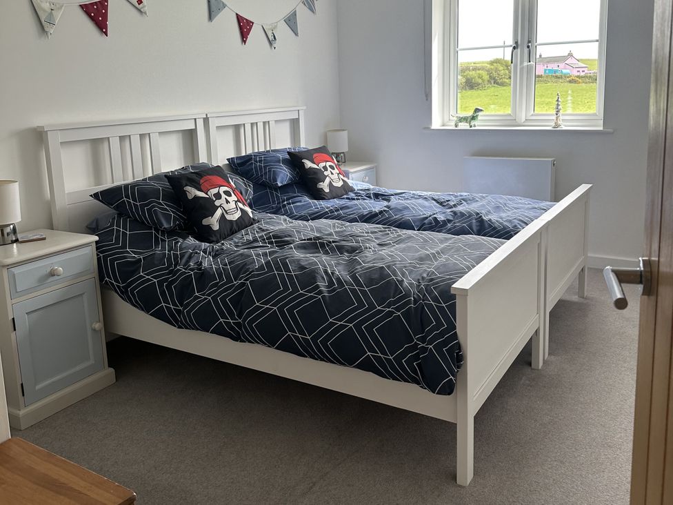 A bedroom with two single beds and a bedside table at 9 Coastguard Cottages in Woolacombe