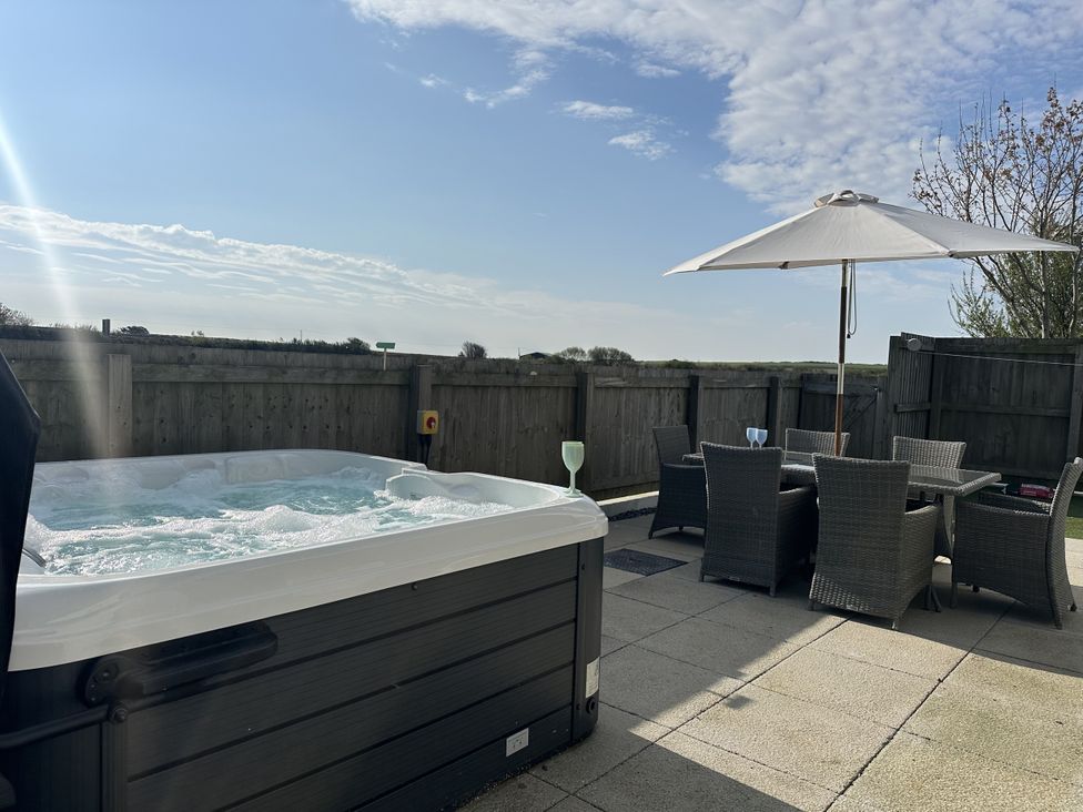 A garden with a hot tub and outdoor seating area at 9 Coastguard Cottages Woolacombe