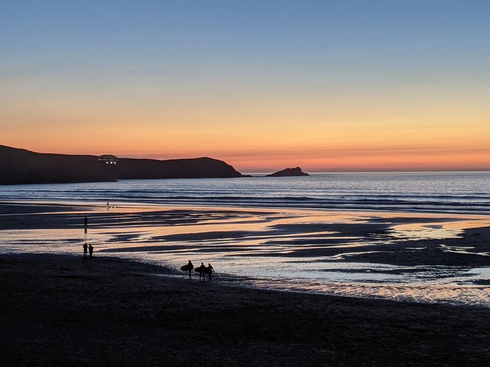 A beach at sunset with people walking at 33 Tre Lowen Newquay