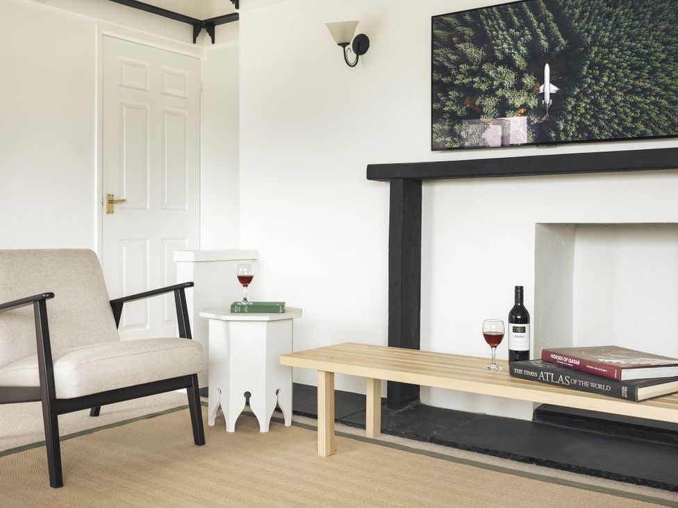 A living room with a chair and a coffee table at Tethers End in Lindeth near Bowness-On-Windermere