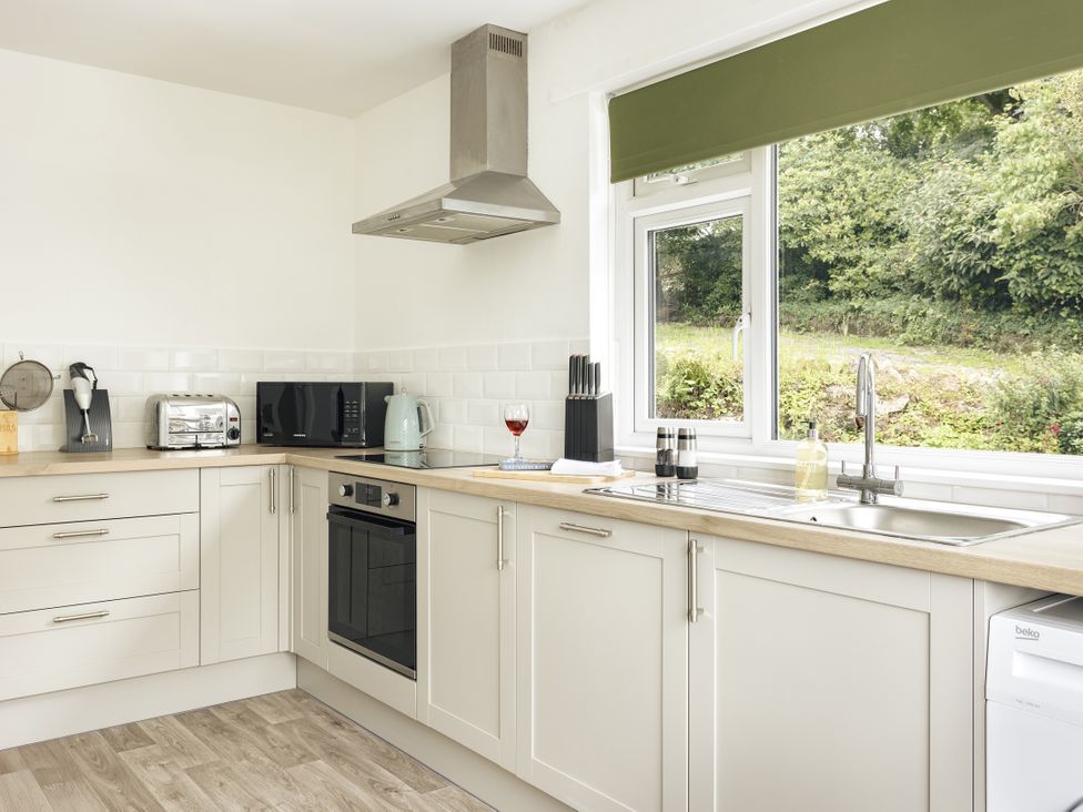 A kitchen with appliances and a window at Tethers End in Lindeth near Bowness-On-Windermere