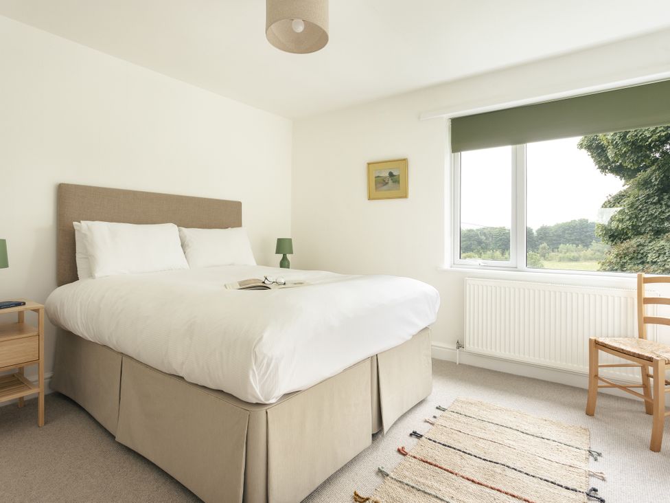 A bedroom with a bed and nightstand at Tethers End in Lindeth near Bowness-On-Windermere