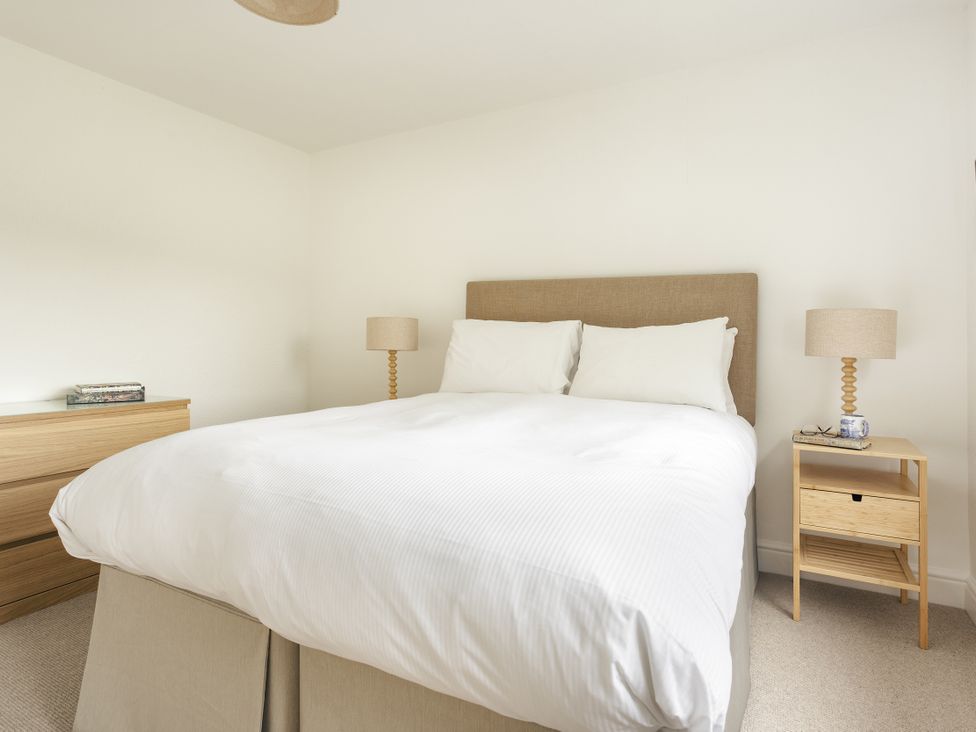 A bedroom with a bed and bedside tables at Tethers End in Lindeth near Bowness-On-Windermere