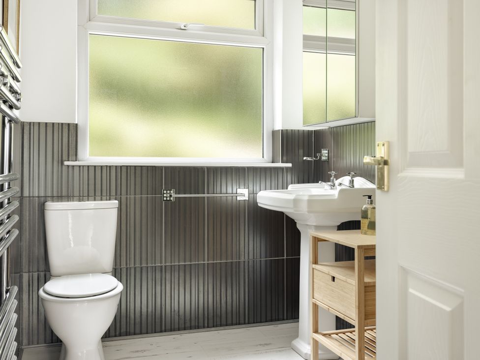 A bathroom with a toilet and sink at Tethers End in Lindeth near Bowness-On-Windermere