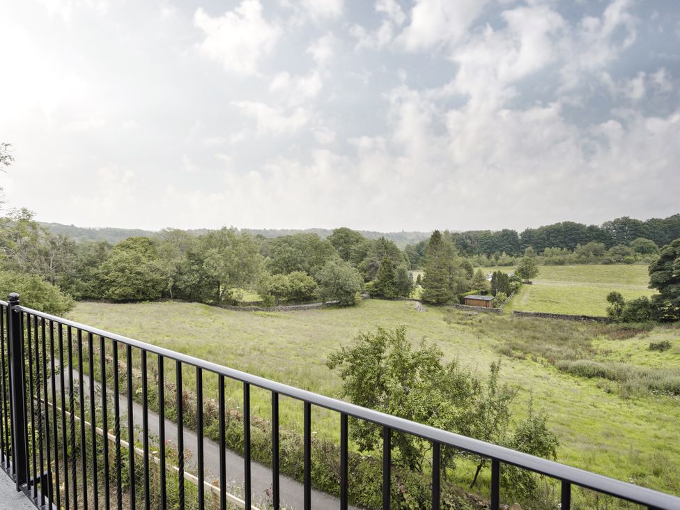 A view of a field and trees from a balcony at Tethers End in Lindeth near Bowness-On-Windermere