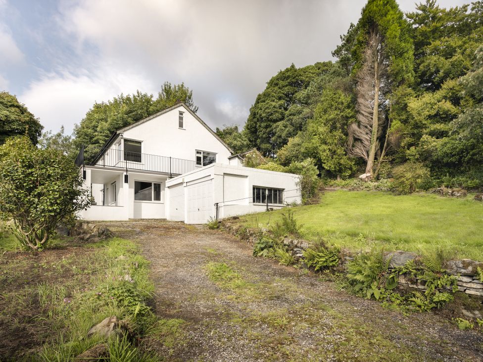 A house with a driveway and trees in the area at Tethers End in Lindeth near Bowness-On-Windermere