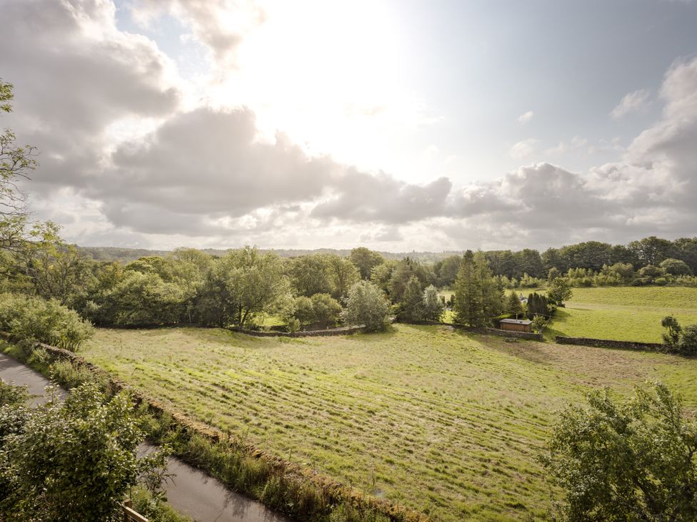 A field with trees and clouds at Tethers End in Lindeth near Bowness-On-Windermere