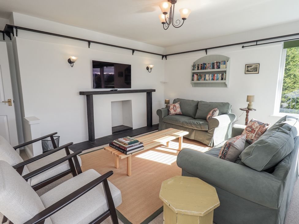 A living room with a sofa, armchairs, and a coffee table at Tethers End in Lindeth near Bowness-On-Windermere