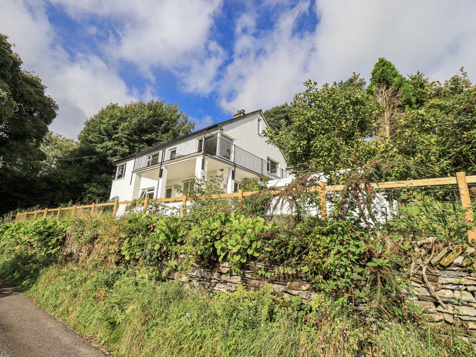 A house with a balcony and surrounding vegetation at Tethers End in Lindeth near Bowness-On-Windermere
