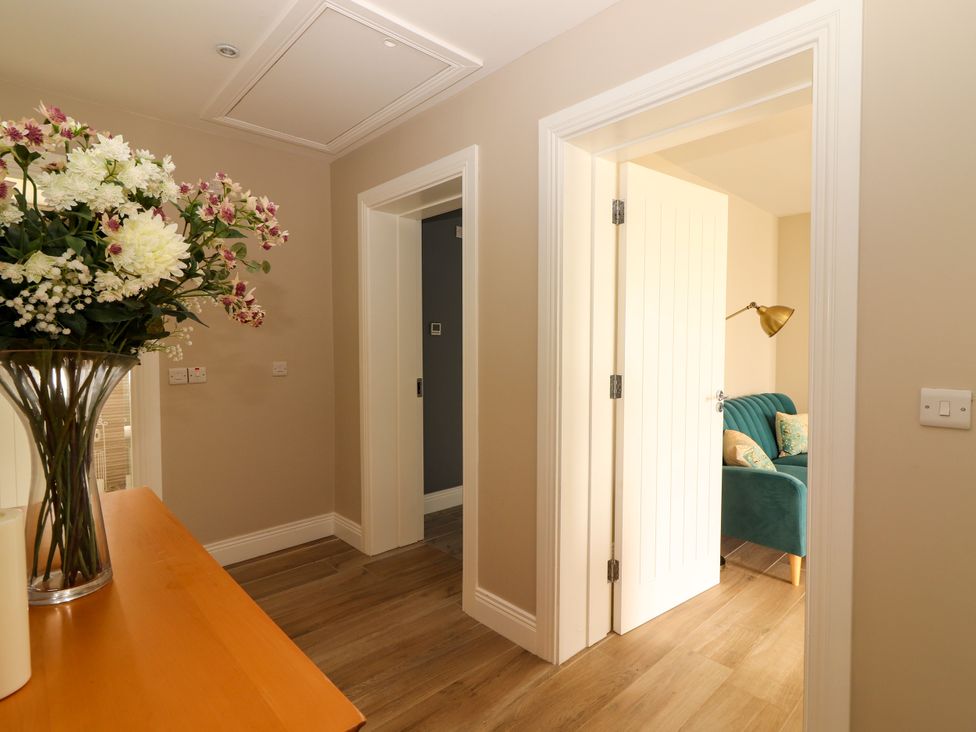 A hallway with flowers on a table and a green sofa at Carrowmore North, Doonbeg, County Clare