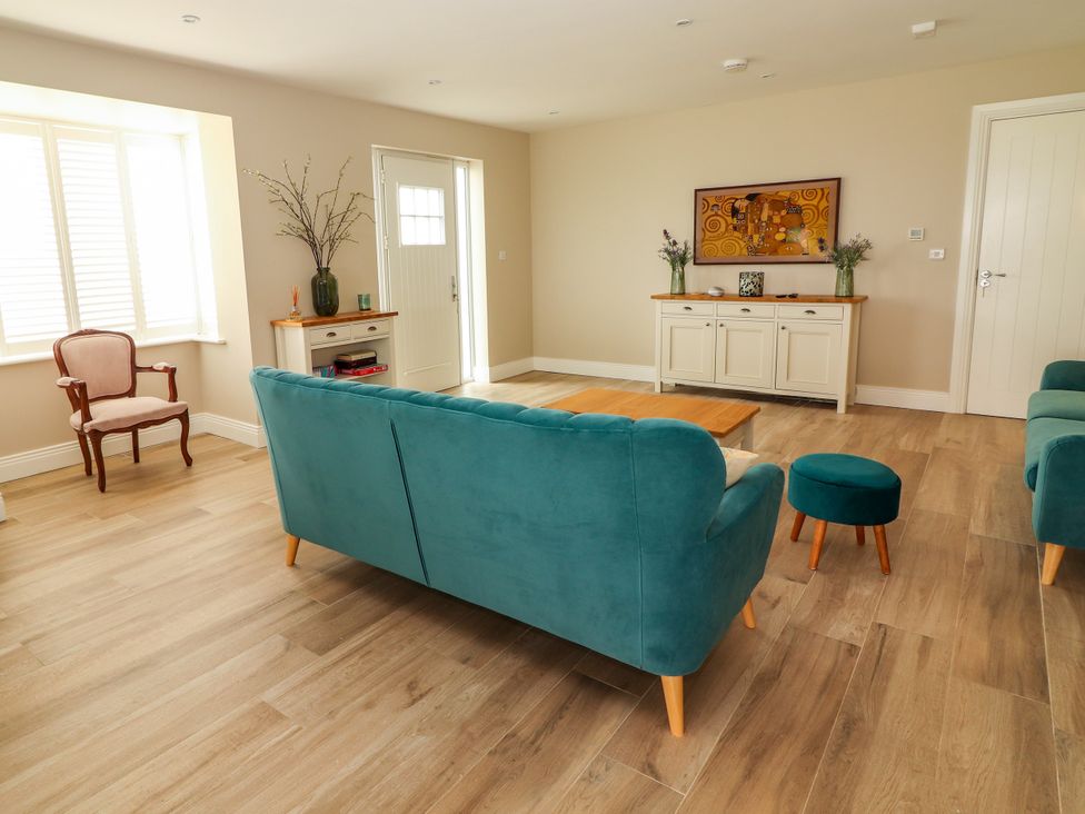 A living room with a sofa and armchair at Carrowmore North in Doonbeg, County Clare