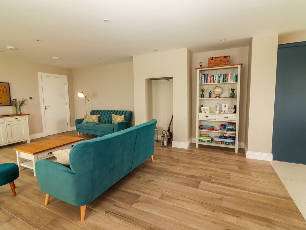A living room with a sofa, coffee table, and bookshelf at Carrowmore North in Doonbeg, County Clare