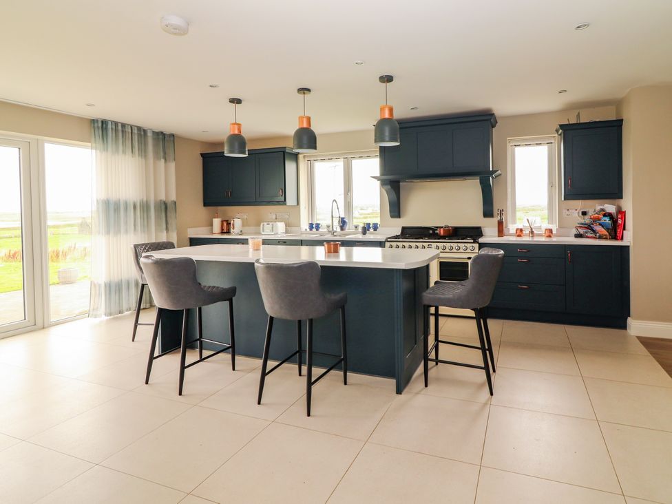 A kitchen with an island and bar stools at Carrowmore North in Doonbeg, County Clare