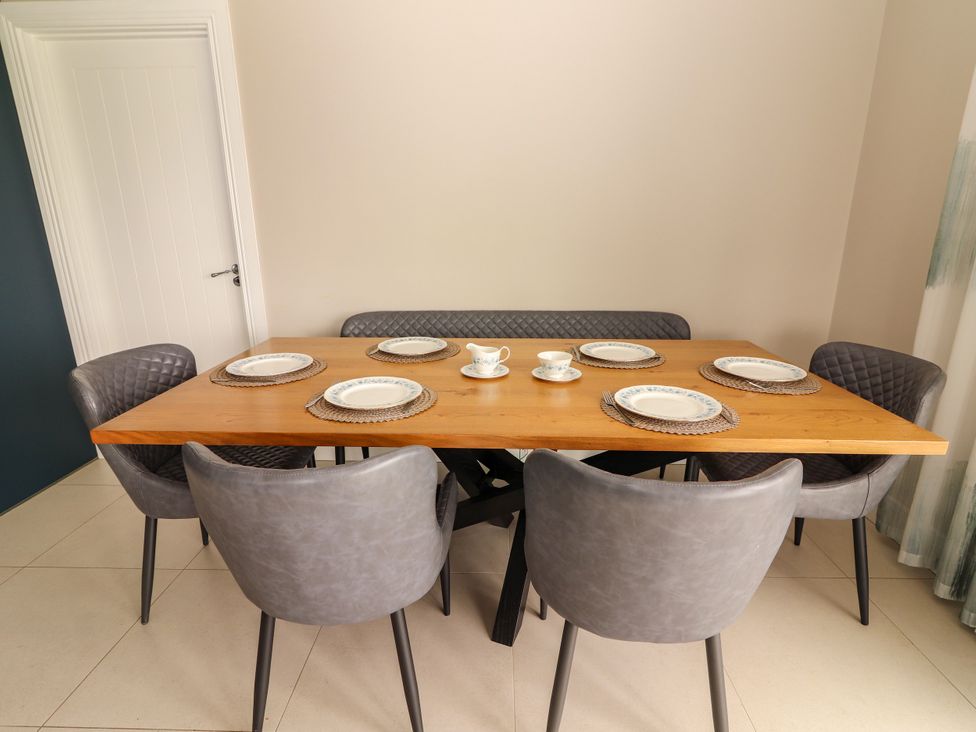 A dining room with a table set for multiple people at Carrowmore North in Doonbeg, County Clare