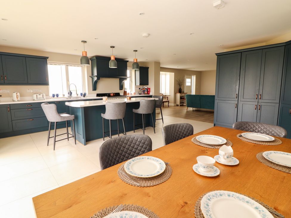 A kitchen with a dining table and stools at Carrowmore North, Doonbeg, County Clare
