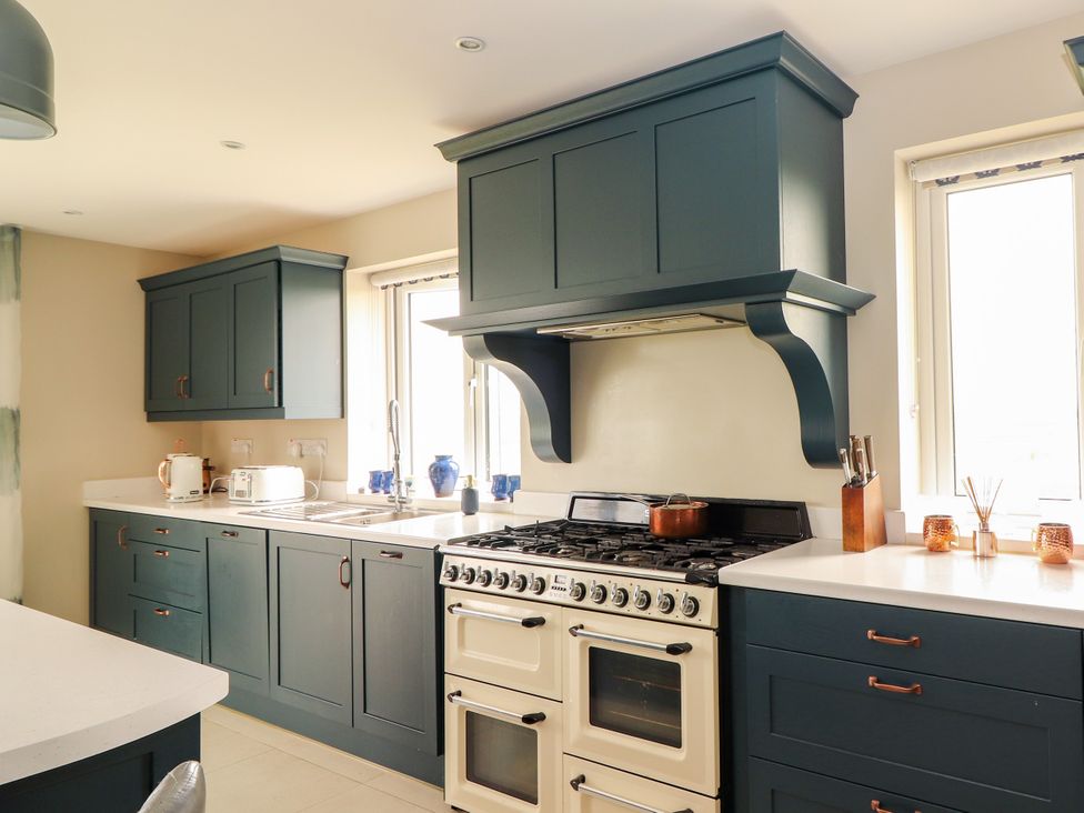 A kitchen with cabinets, oven, sink and countertop at Carrowmore North, Doonbeg, County Clare