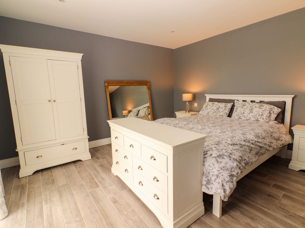 A bedroom with a bed and a wardrobe at Carrowmore North, Doonbeg, County Clare