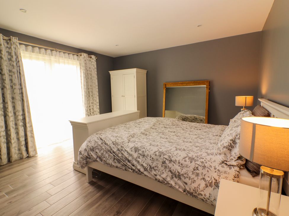 A bedroom with a bed and wardrobe at Carrowmore North in Doonbeg, County Clare