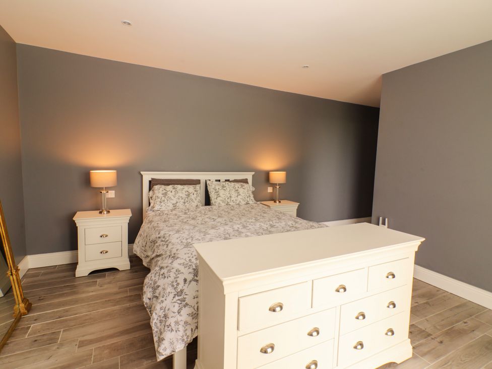 A bedroom with a bed and nightstands at Carrowmore North, Doonbeg, County Clare