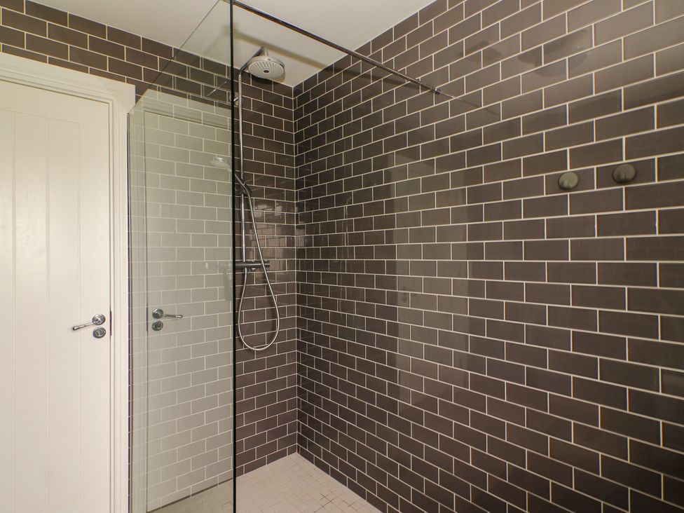 A shower with a glass panel and tile walls at Carrowmore North in Doonbeg, County Clare