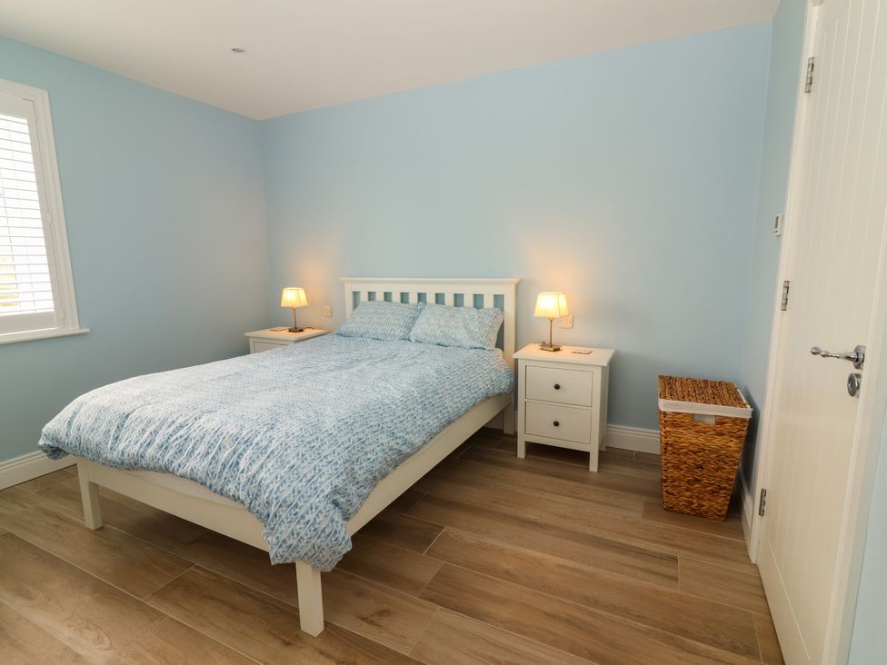 A bedroom with a bed and nightstand at Carrowmore North in Doonbeg, County Clare