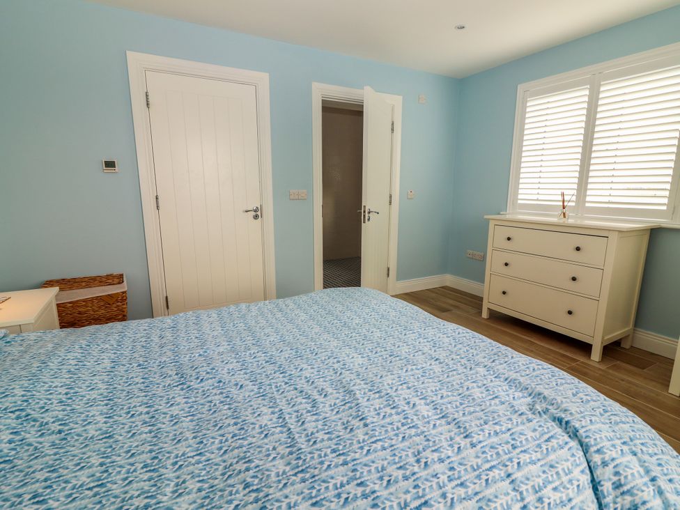 A bedroom with a bed and a dressing table at Carrowmore North in Doonbeg, County Clare