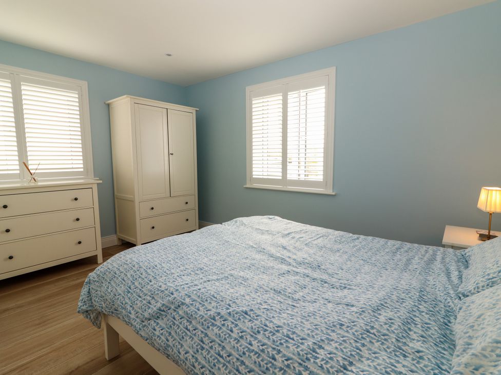 A bedroom with a bed and dresser at Carrowmore North in Doonbeg, County Clare