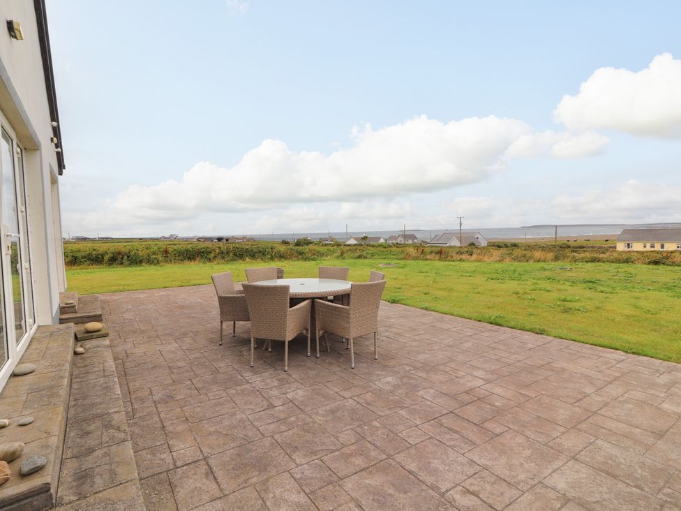 An outdoor patio with a table and chairs at Carrowmore North, Doonbeg, County Clare