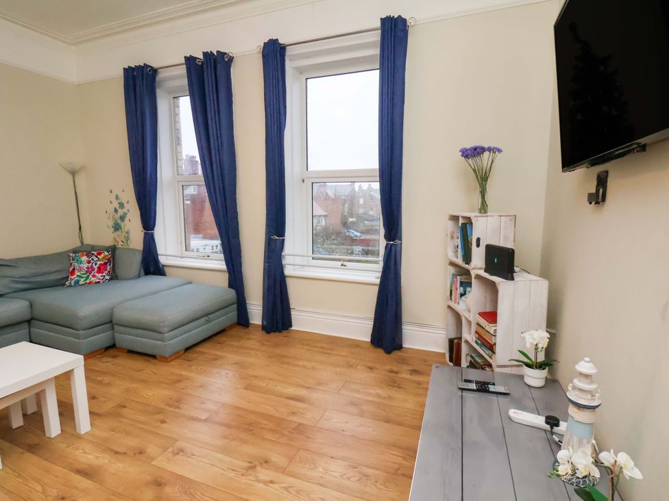A living room with a sofa, coffee table, and TV at Wellington Lodge in Bridlington