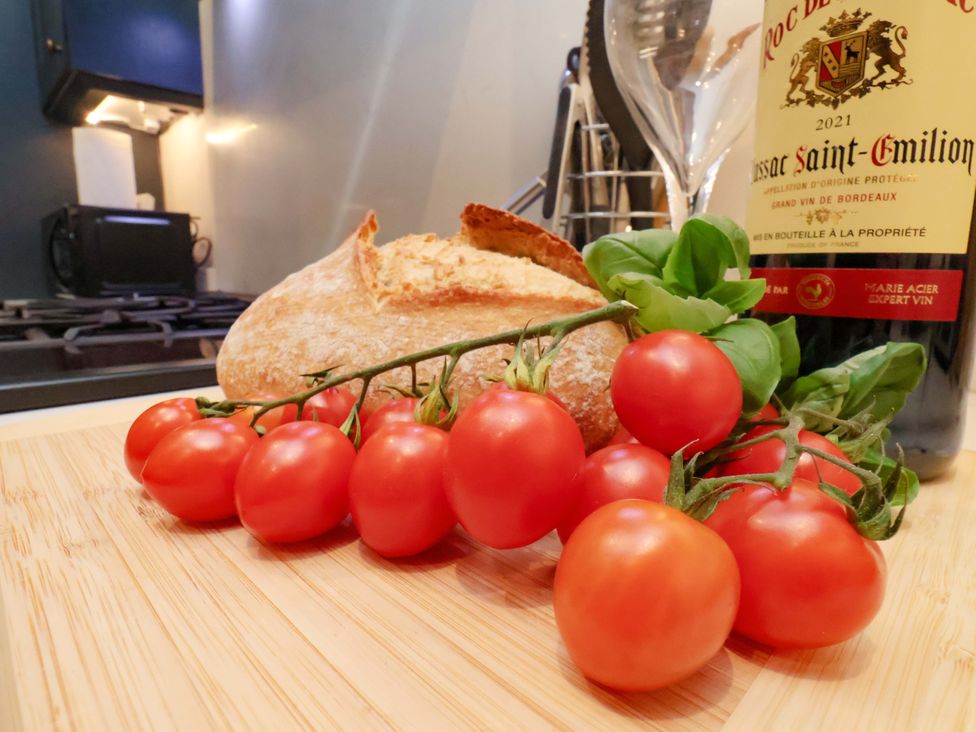 A kitchen counter with tomatoes, bread, and a bottle of wine at Wellington Lodge in Bridlington