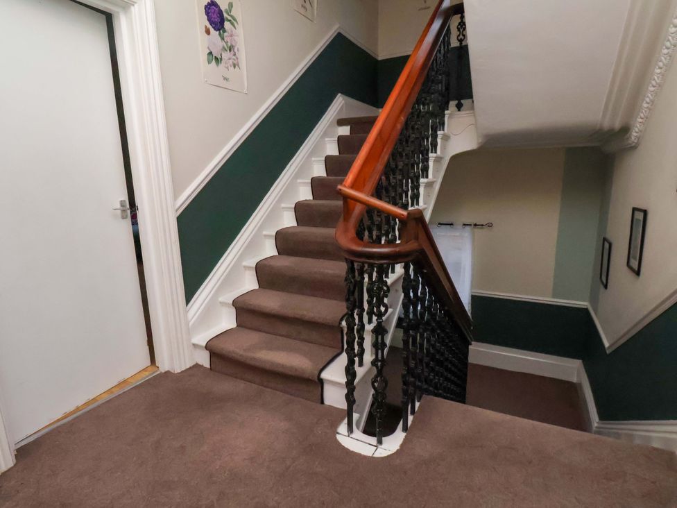 A hallway with stairs and a door at Wellington Lodge in Bridlington