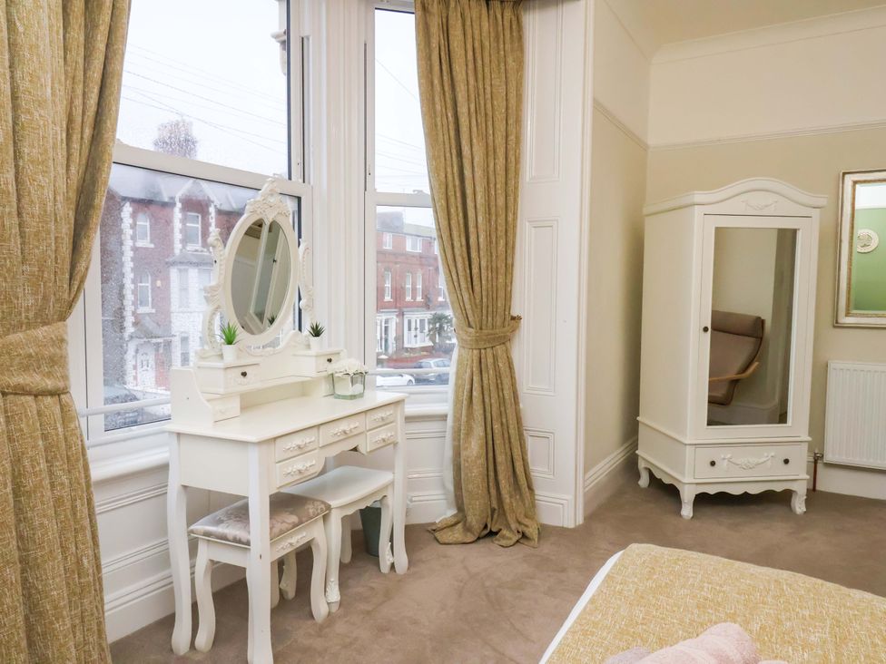 A bedroom featuring a dressing table and a wardrobe at Wellington Lodge in Bridlington