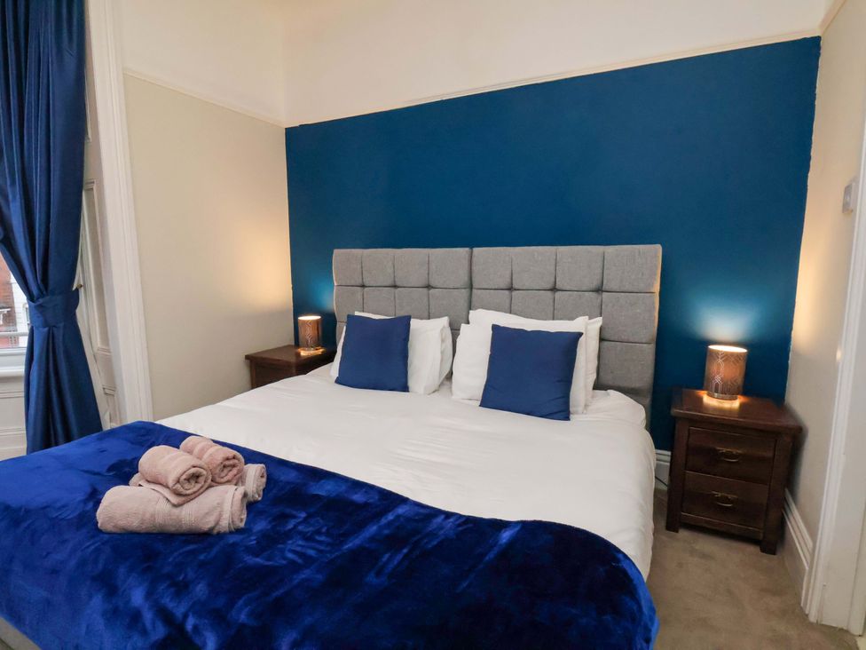 A bedroom with a bed and nightstands at Wellington Lodge in Bridlington