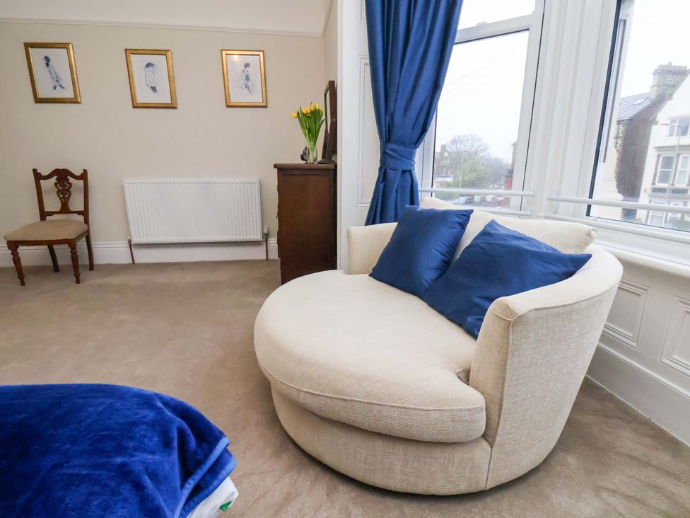 A living room with a curved sofa and chair at Wellington Lodge in Bridlington