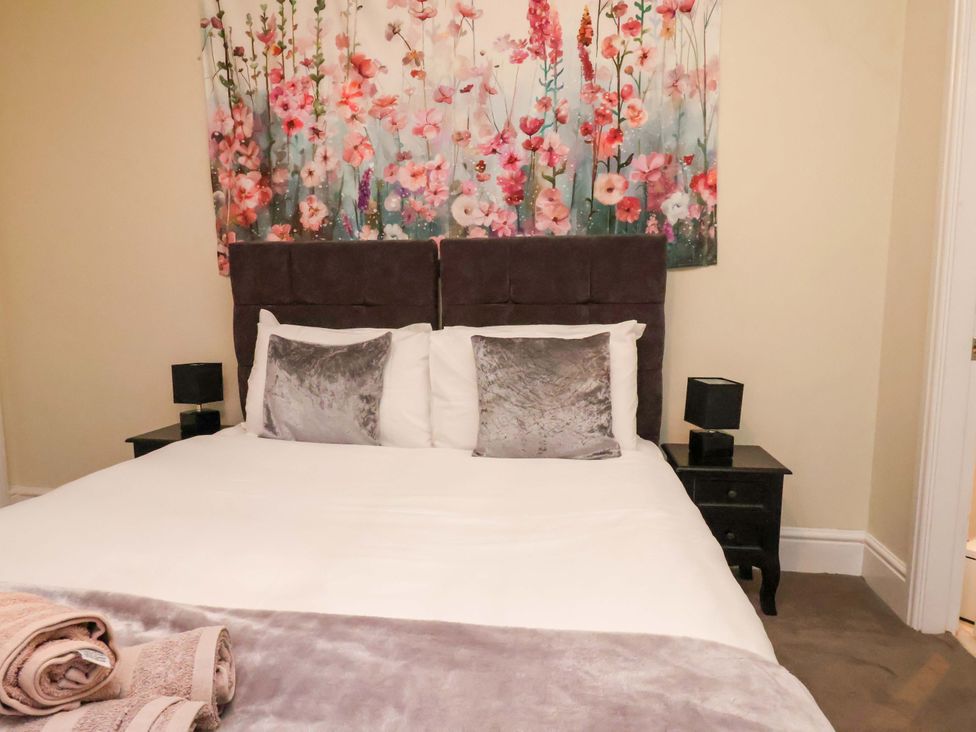 A bedroom featuring a bed with bedding and wall art at Wellington Lodge in Bridlington