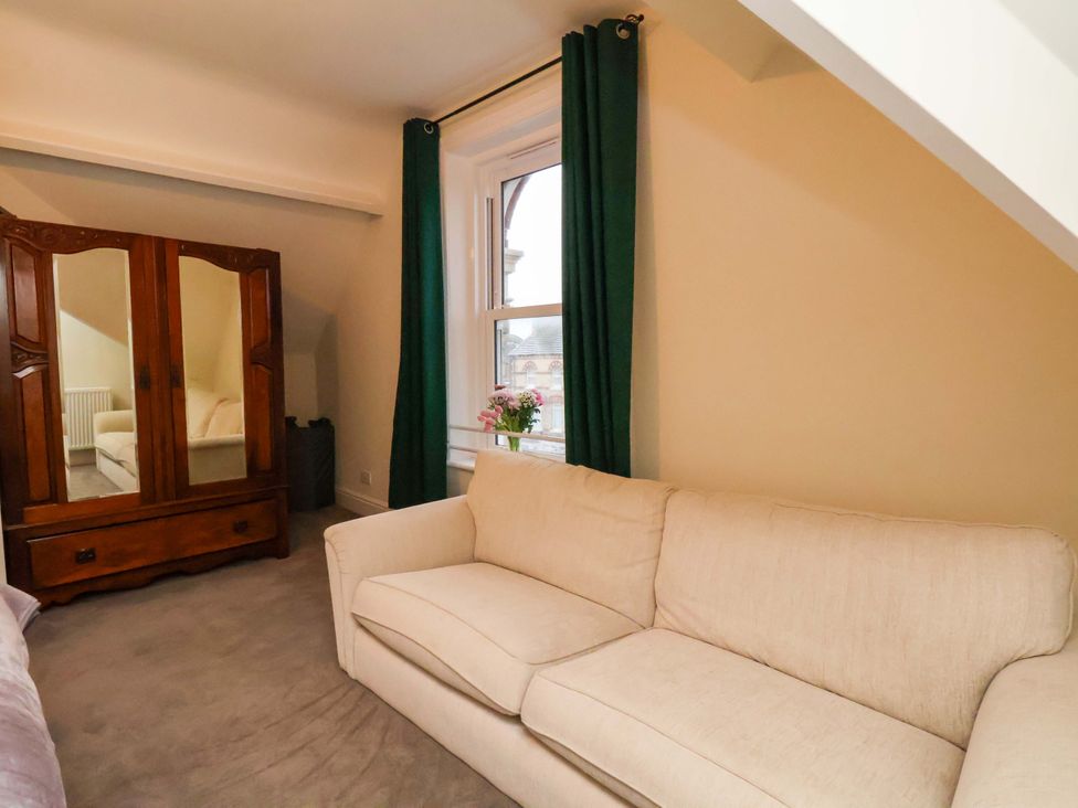 A sitting room with a sofa and mirror cabinet at Wellington Lodge in Bridlington